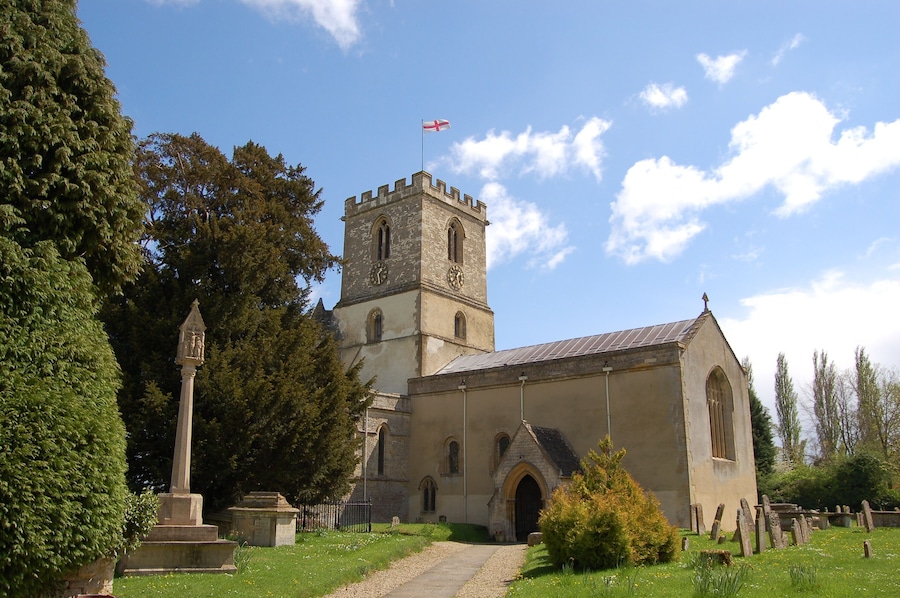 A historic church with a tall tower and a flag.