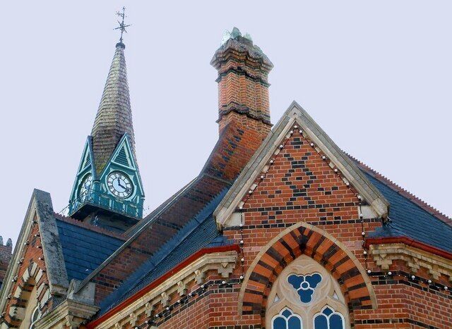 Una iglesia con una torre de campanario y un campanario puntiagudo.