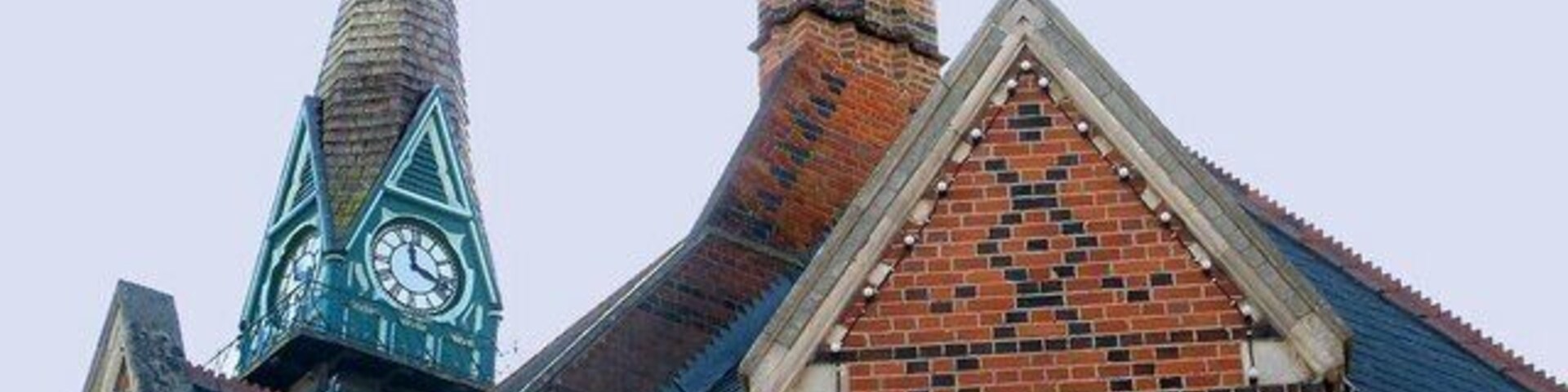 Una iglesia con una torre de campanario y un campanario puntiagudo.