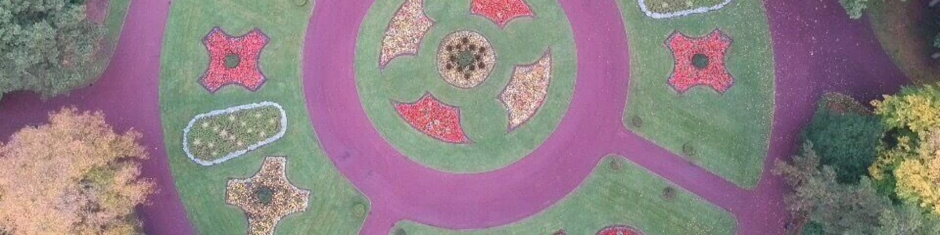 An aerial view of a circular garden with distinct geometric patterns and a central circular area.