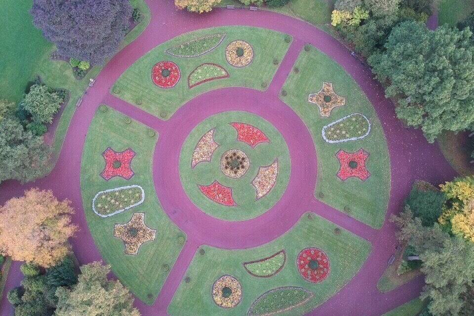 Vista aérea de un jardín circular con patrones geométricos definidos y una zona circular central.