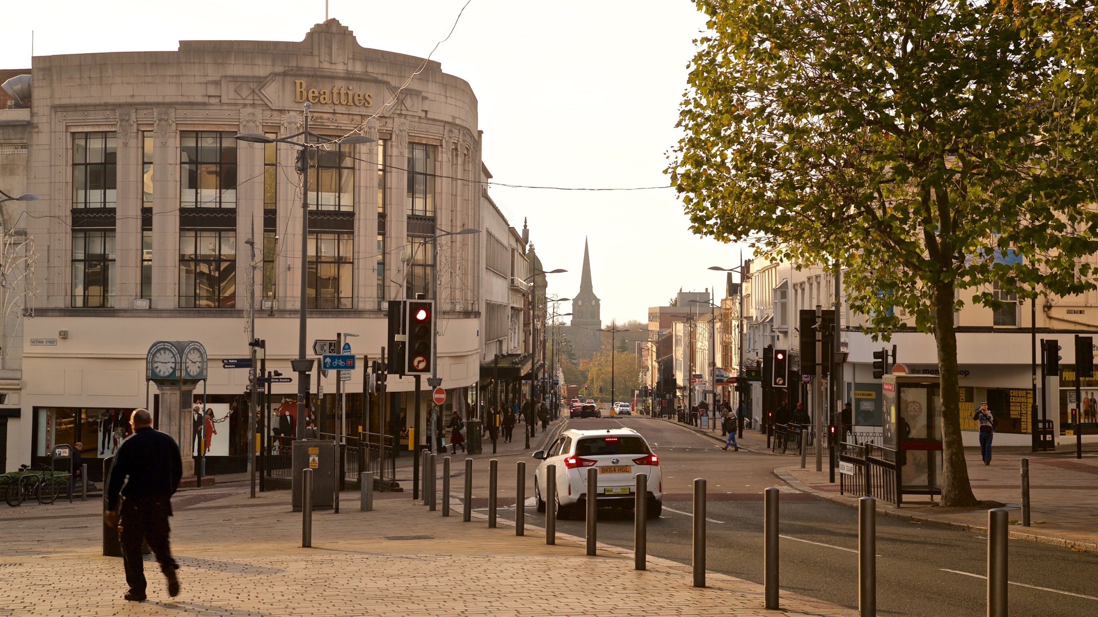 A street with a Beatties building, a clock tower, and a tree.