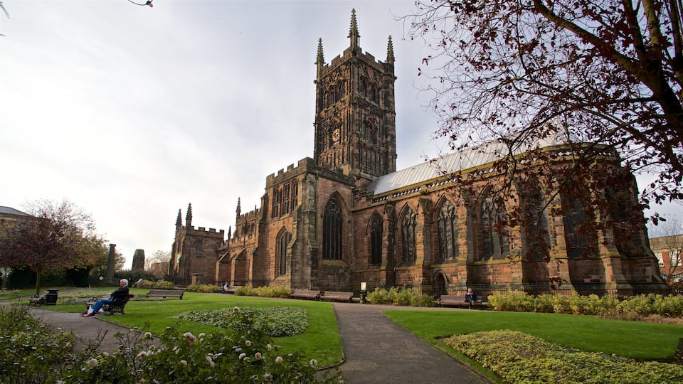 A historic church with a tall tower and a well-maintained garden.