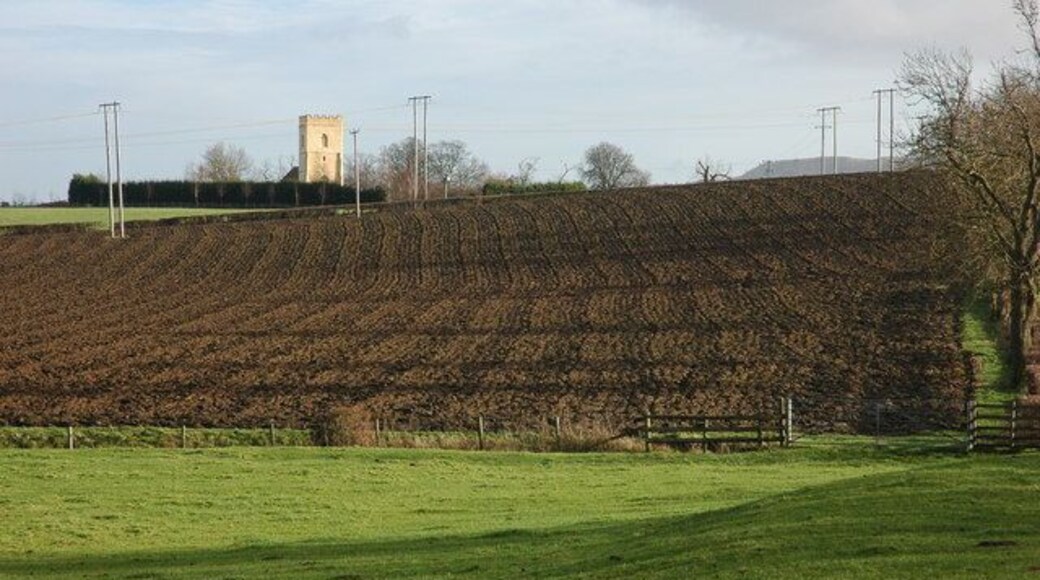 Farmland below Strensham Church Farmland between the moat on the site of the long gone Strensham Castle and the church which can be seen on the bank. The top of Bredon Hill can be seen on the horizon.