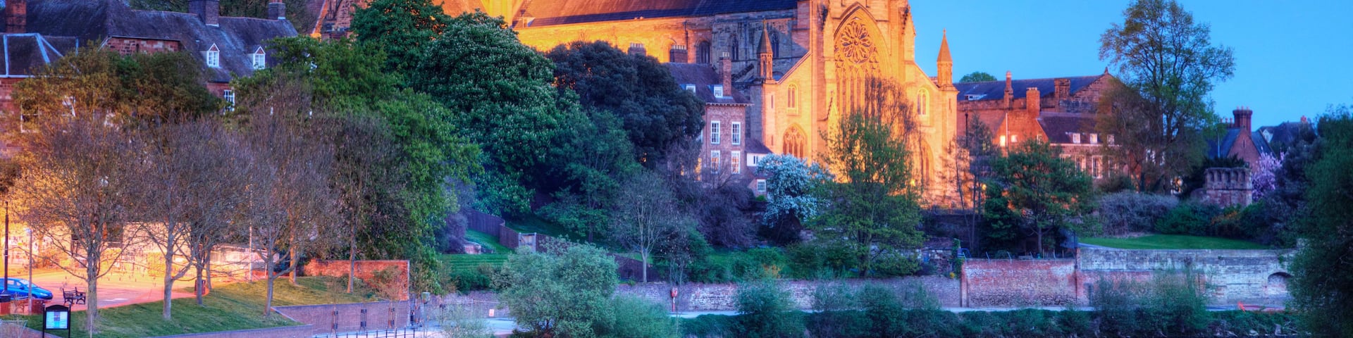 Worcester Cathedral floodlit on a spring evening and reflected in the River Severn.