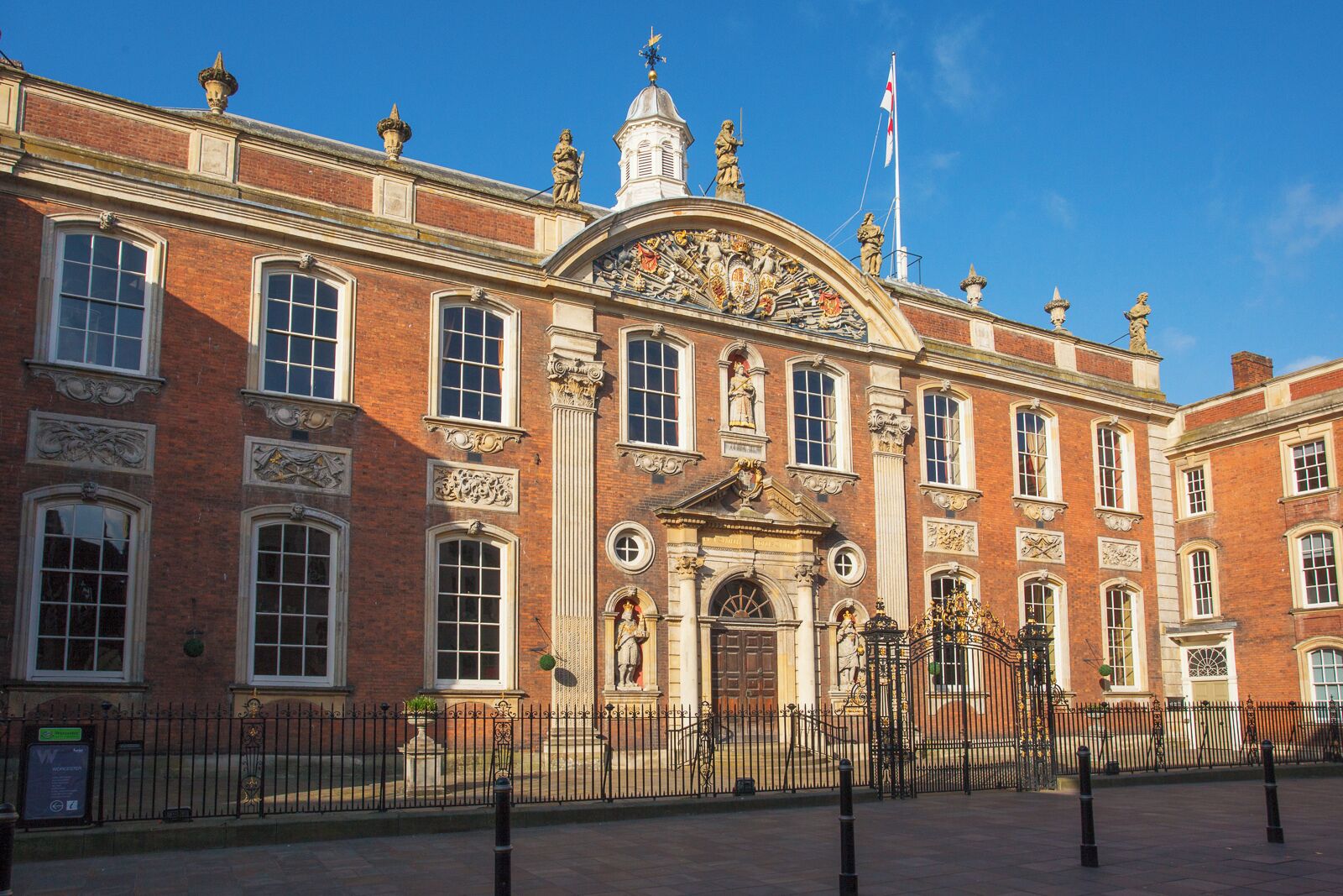 A historic building with red brick walls, large windows, and ornate decorations.