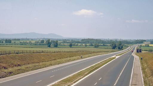 Northward on M5 Motorway at Strensham, 1964. View northward, towards Birmingham - at this date only to Junction 4 (Lydiate Ash), and not much traffic! In the distance are the Malvern Hills (Worcester Beacon (1,355 ft.), North Hill (1,307 ft.))