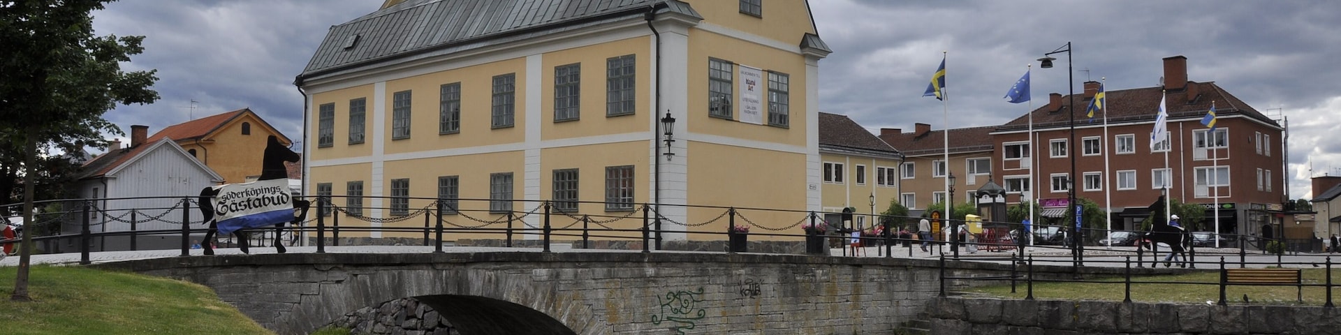 Un edificio histórico con una torre del reloj, un puente y un canal.