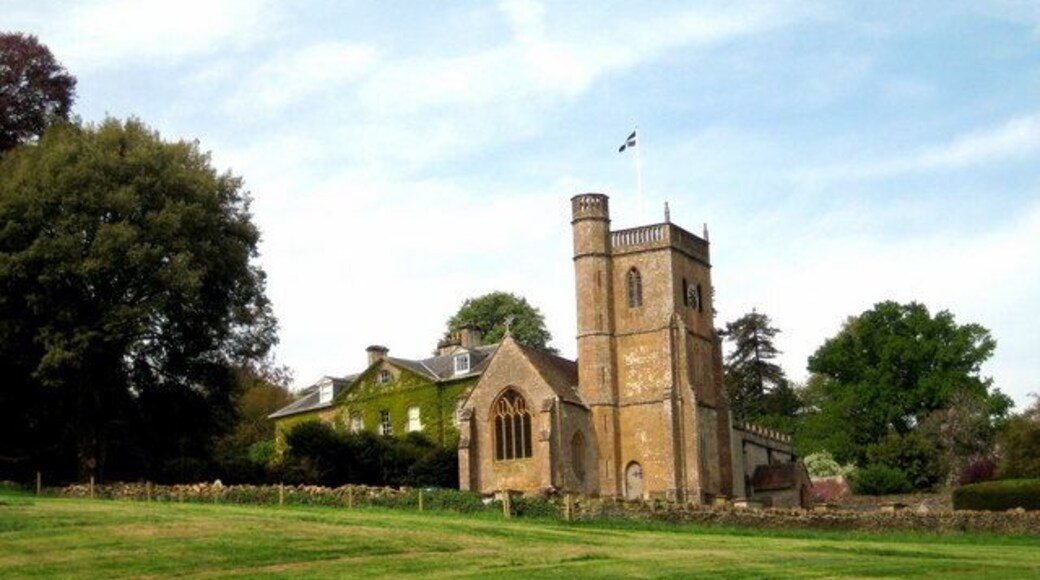 Coker Court and St Michael's Church East Coker, near to East Coker, Somerset, Great Britain. Coker Court was bought by Archdeacon Helyar in 1616 and remained in the hands of the same family until the middle of the last century. There have been many alterations - the east front visible was designed in the 18th Century by Sir William Chambers who also was the architect of Somerset House and the Pagoda in Kew Gardens. Both the church and the house are built in Ham stone. The photograph was taken literally minutes after the forager had cleared the silage grass in the park.