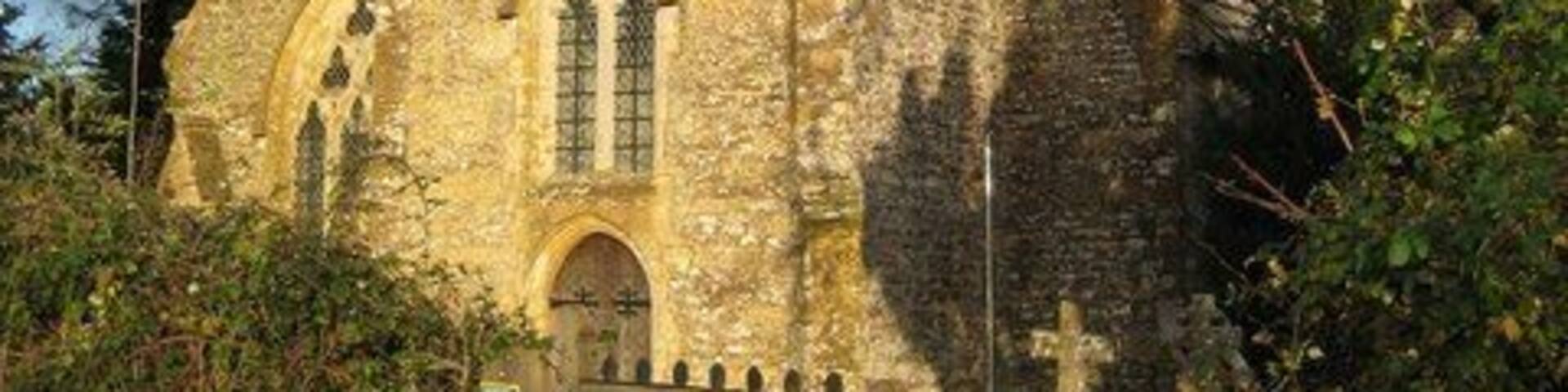 A stone church with a tall tower and arched windows.