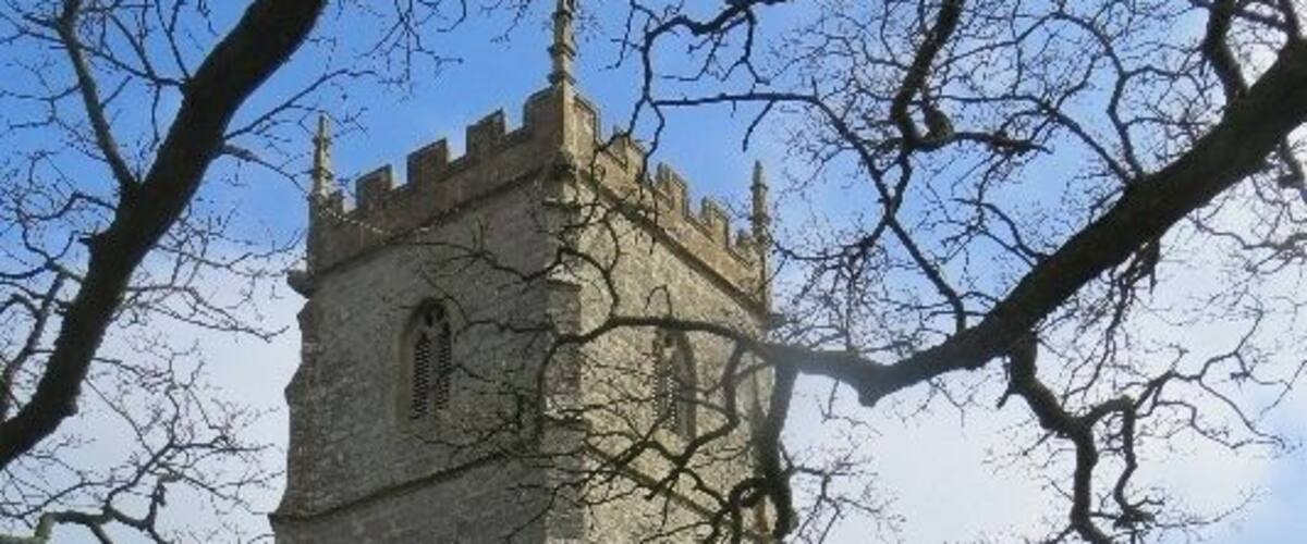 A stone church with a tall tower and arched windows.