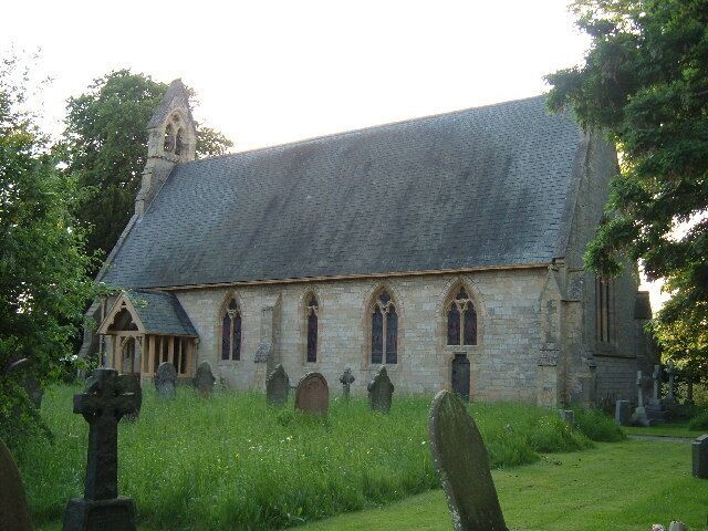 A church with a steeply pitched roof, arched windows, and a stone facade.
