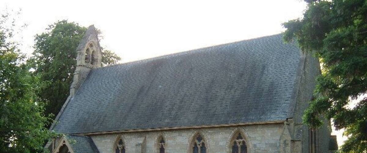 A church with a steeply pitched roof, arched windows, and a stone facade.