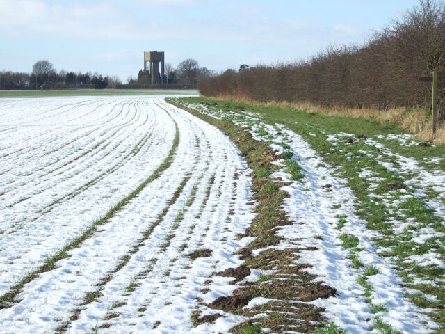 Riccall water tower from across the A19. Photo taken from King Rudding Lane. This year's heavy snow has gone from the village but lingers on in the ruts of the ploughed fields. No matter what angle it is viewed from Riccall water tower (in the distance) always looks alien.
