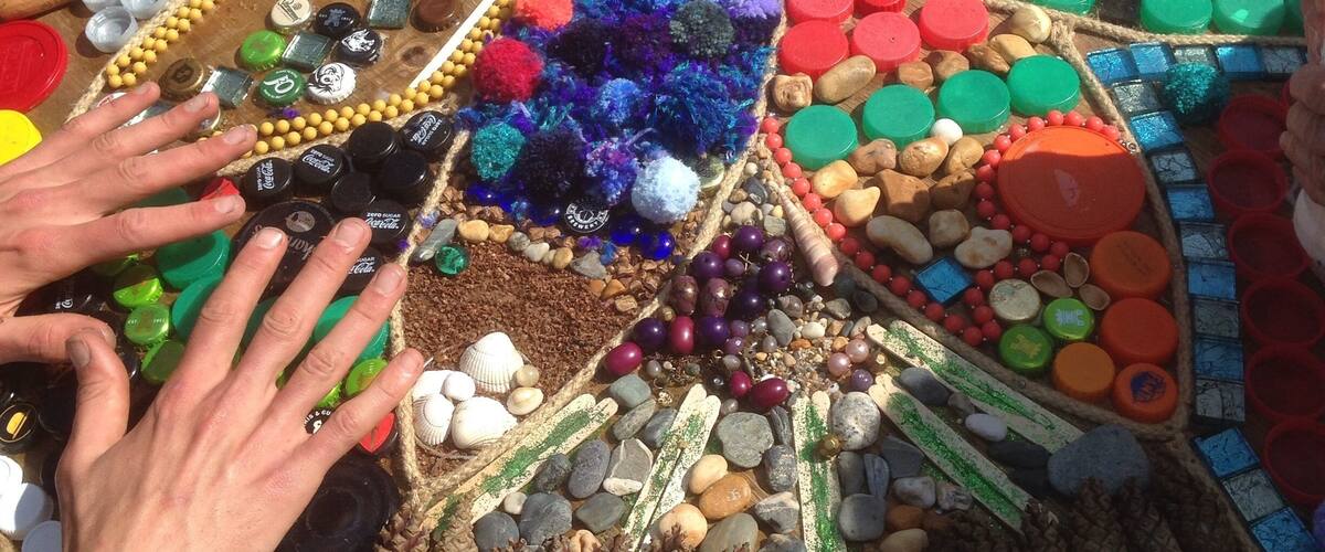 A mosaic table with colorful bottle caps and beads.