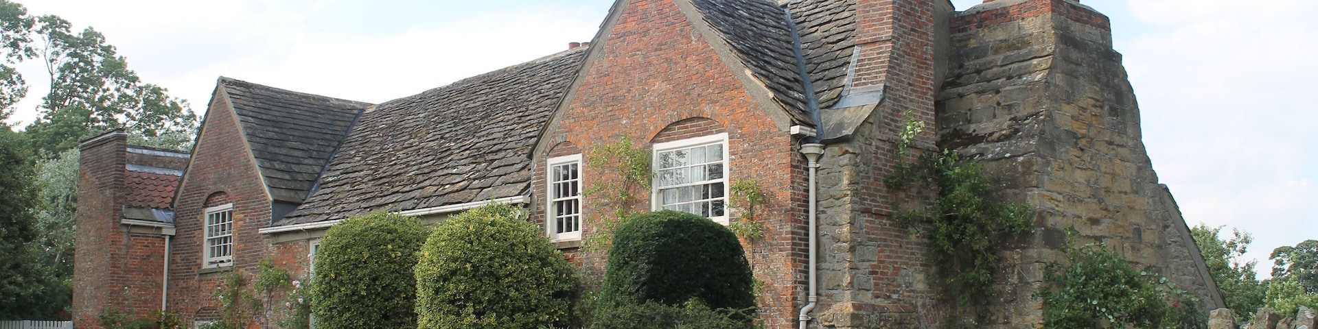 The south entrance to Shandy Hall. The wrought iron gates include a bar in the shape of one of the plot-lines drawn by Laurence Sterne in The Life and Opinions of Tristram Shandy.