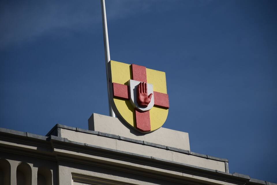 Un edificio con un emblema de escudo que muestra una mano roja.