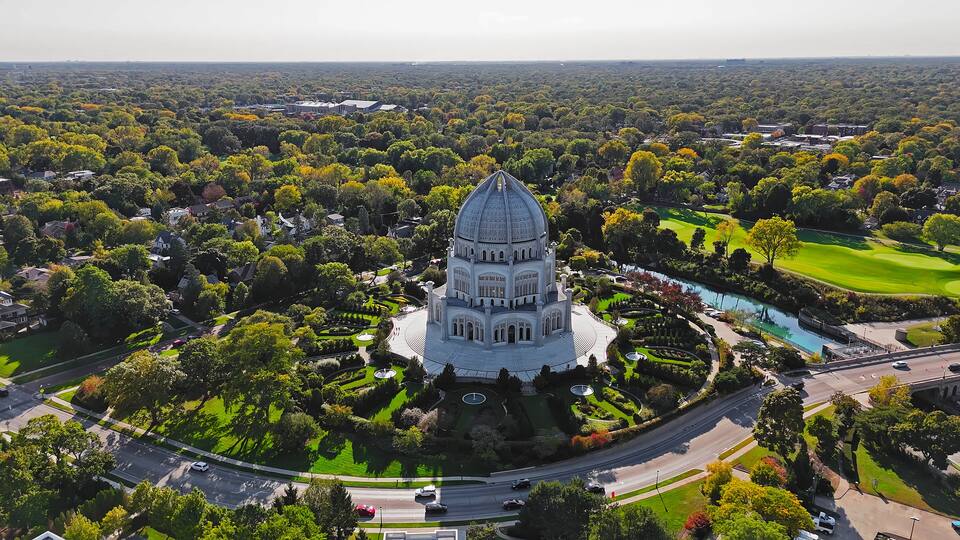 A large, domed building surrounded by lush greenery and a golf course.