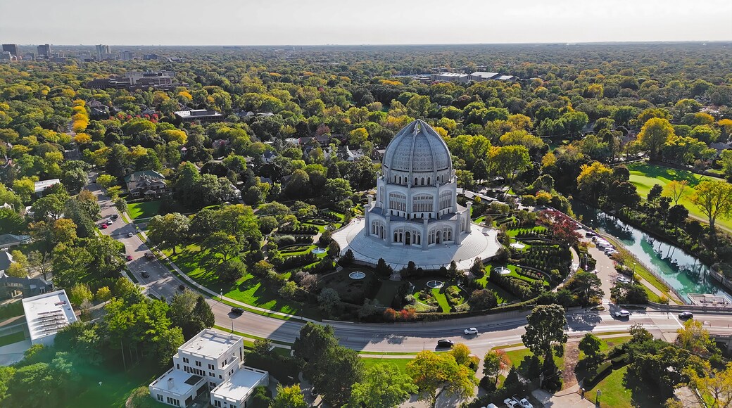 Aerial View of Baha'i House of Worship in Illinois. High-angle aerial view of the Baha'i House of Worship in Wilmette, Illinois, surrounded by lush greenery, gardens, and urban landscape.