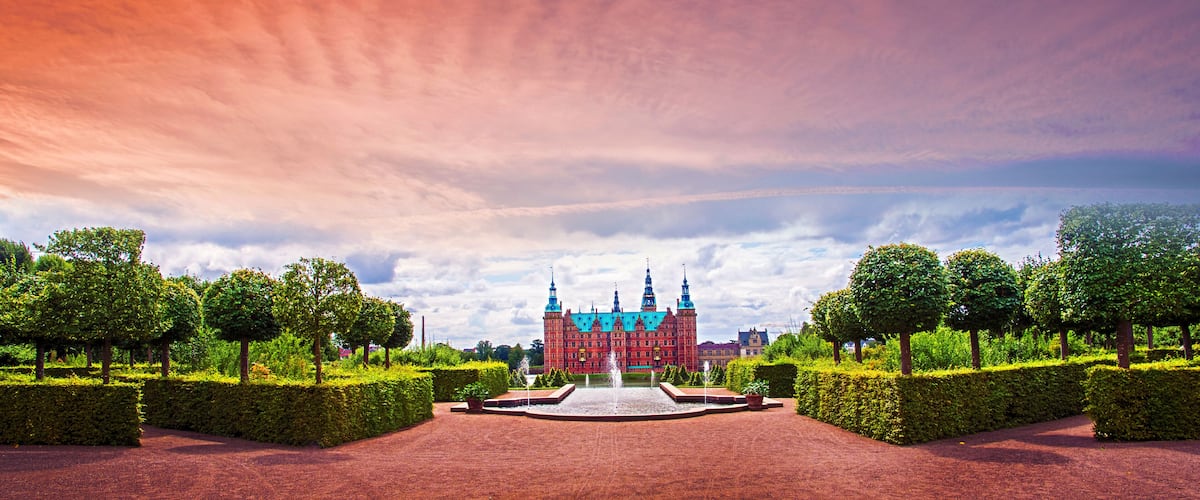 beautiful landscape with fountain and magical incredible gardens and park Frederiksborg slot Castle near Copenhagen. Hillerod, Denmark at sunset. Popular tourist atraction.