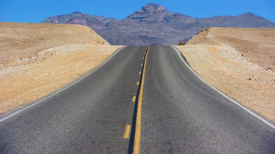 A road leading to a mountain range.