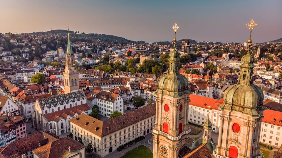 A historic cityscape with prominent domed towers and a clock tower.