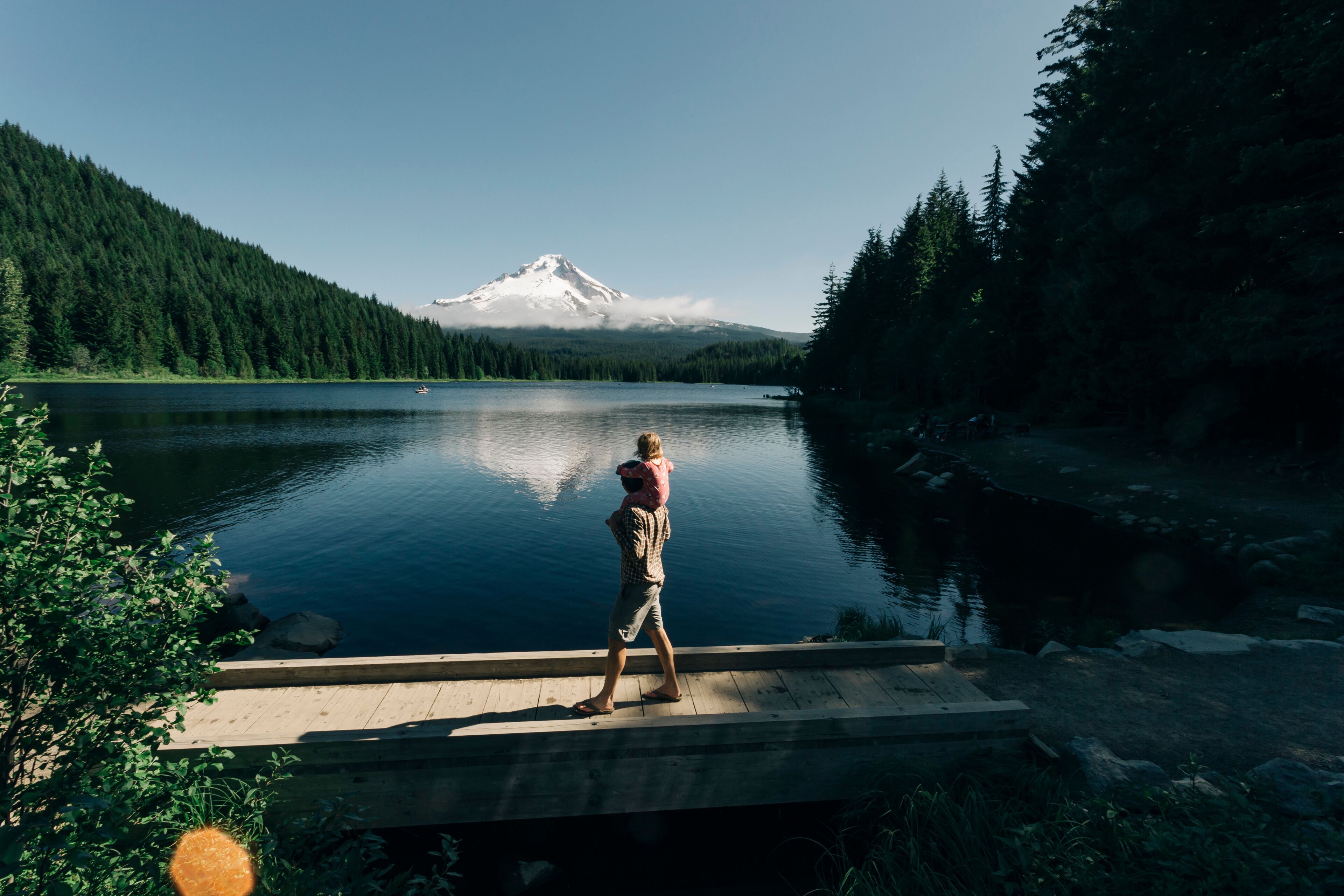 A father carries his daughter on his shoulders at Trillium Lake, OR.