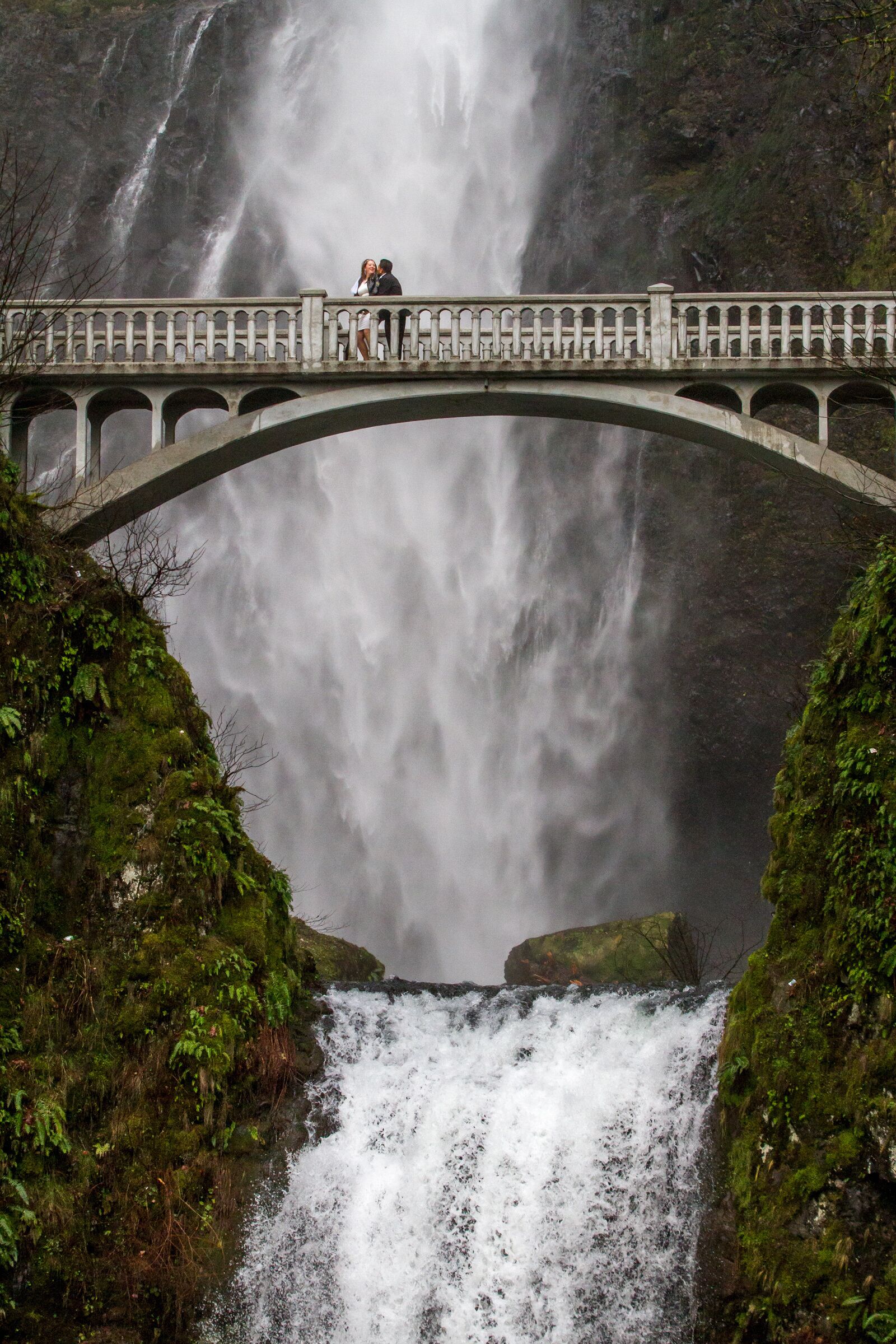 waterfall with bridge and a couple
