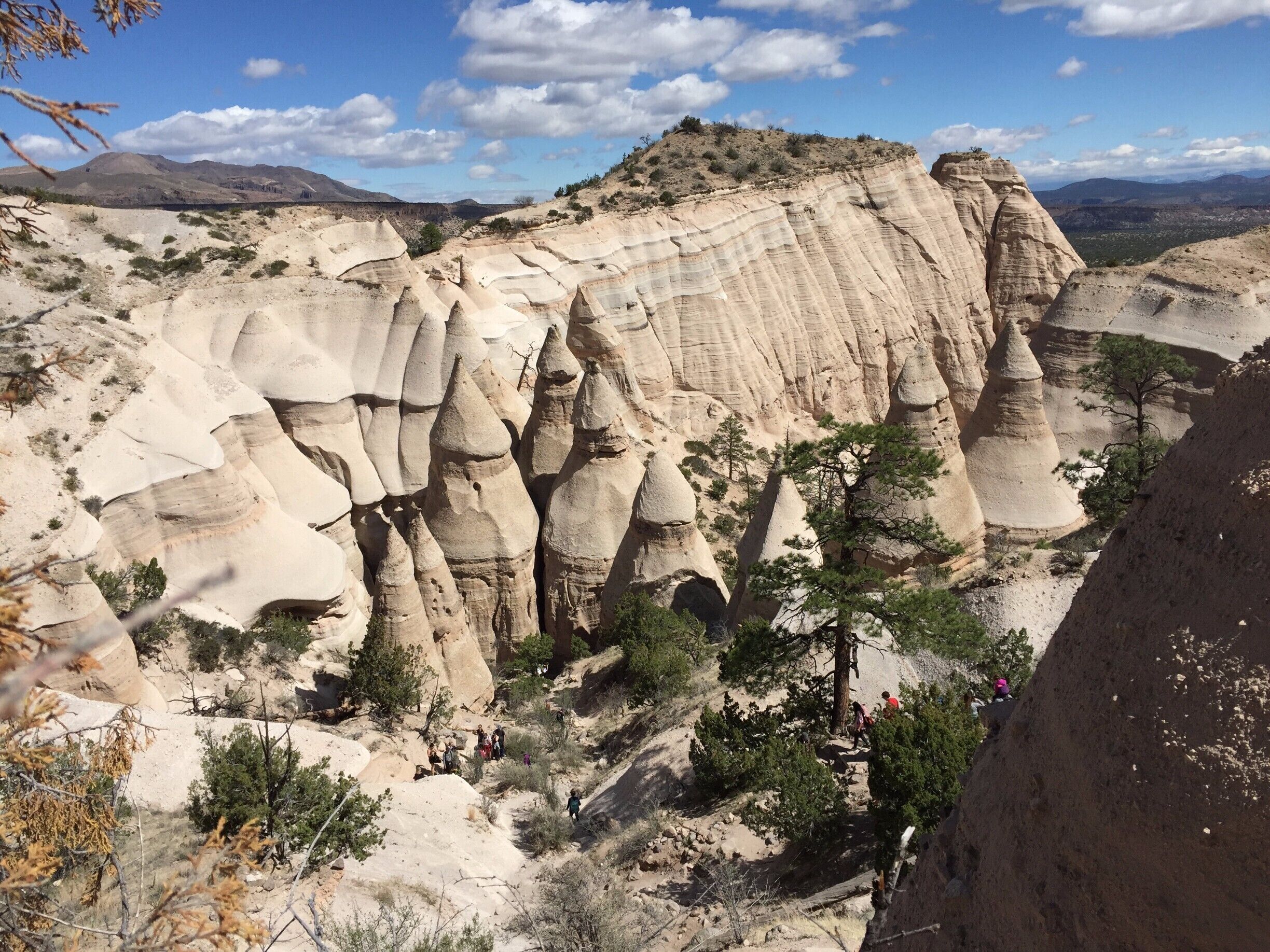 A landscape with prominent hoodoos and a group of hikers.