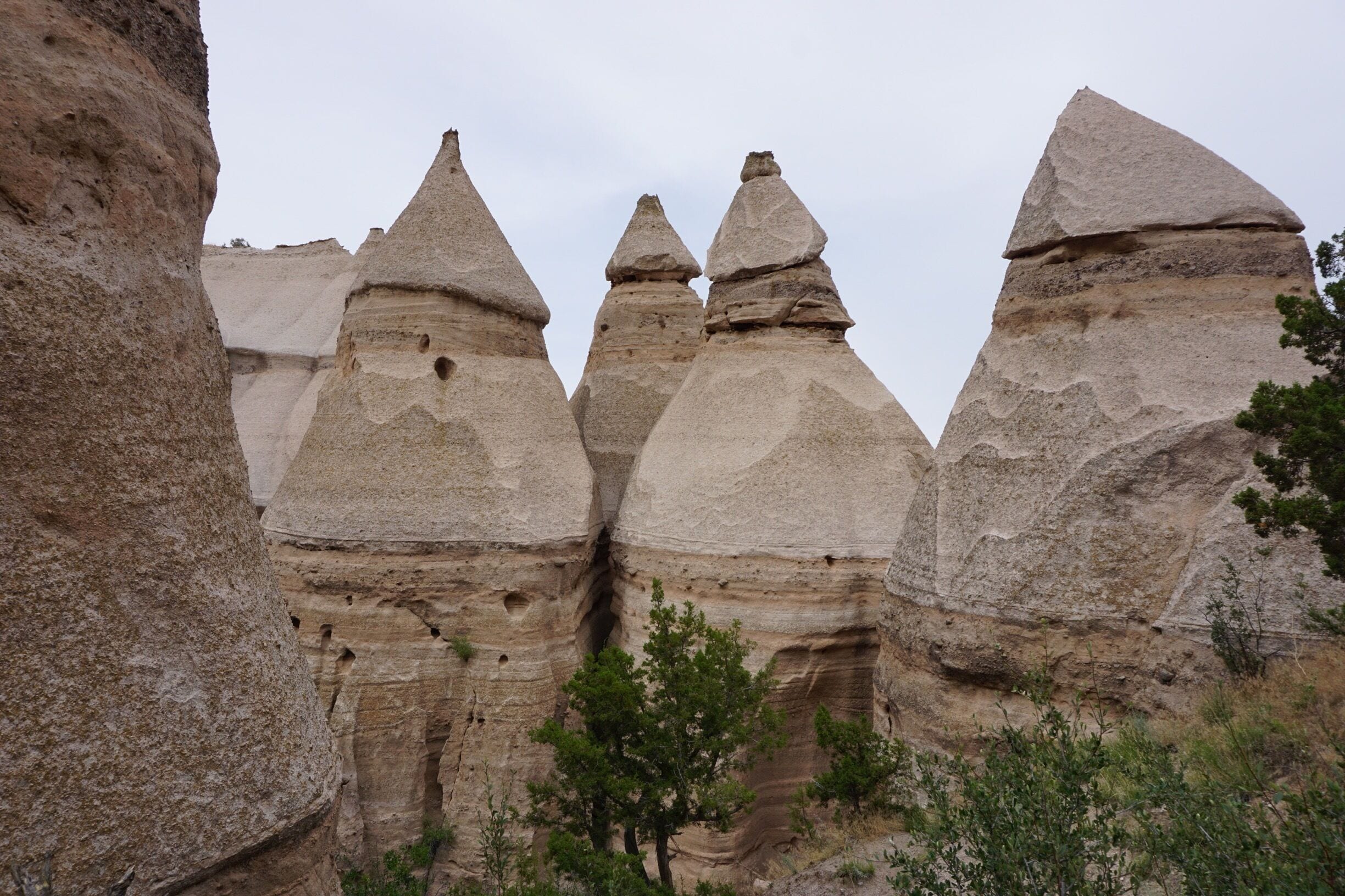 A landscape with unique rock formations resembling mushrooms, surrounded by greenery.