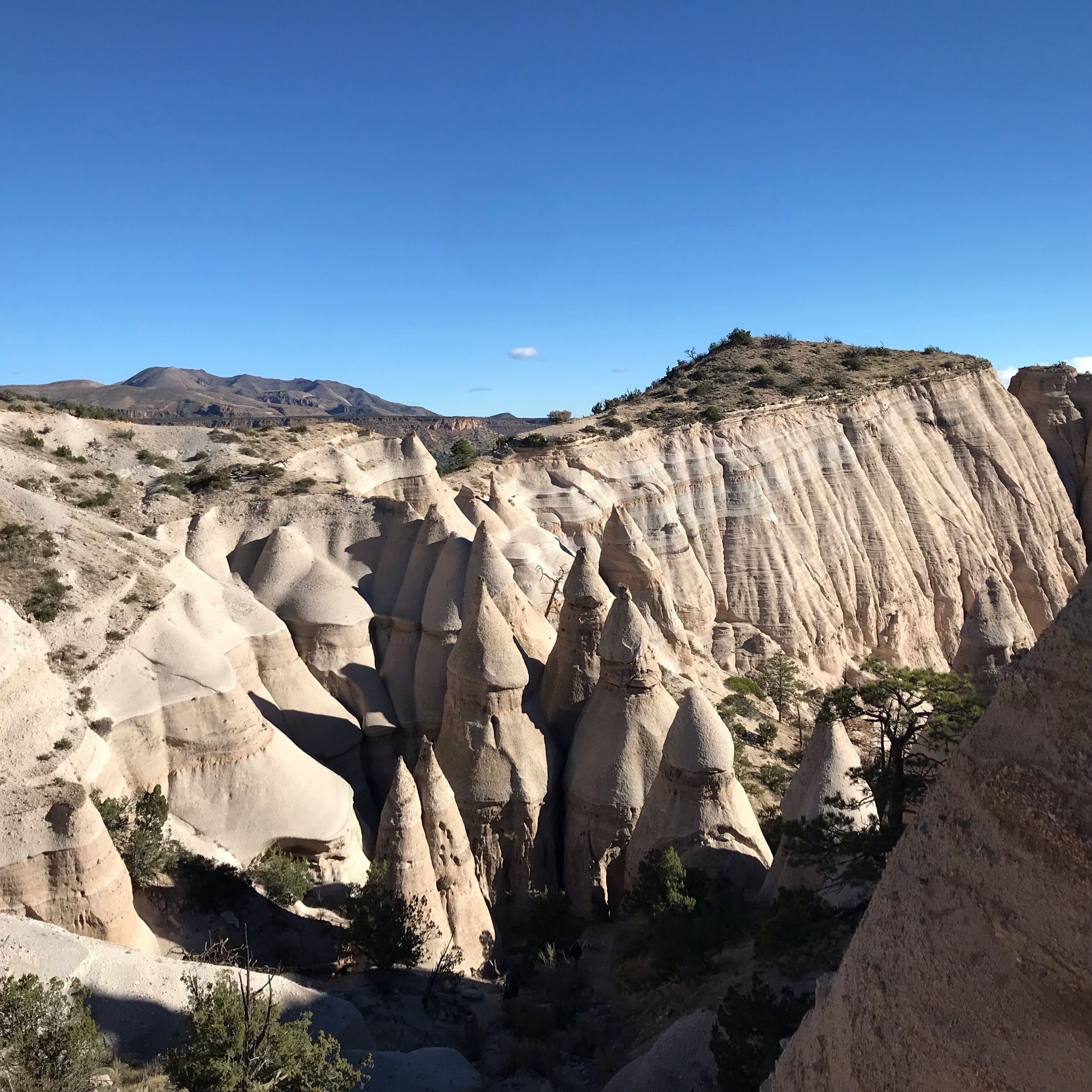 A landscape with prominent hoodoos and a clear blue sky.