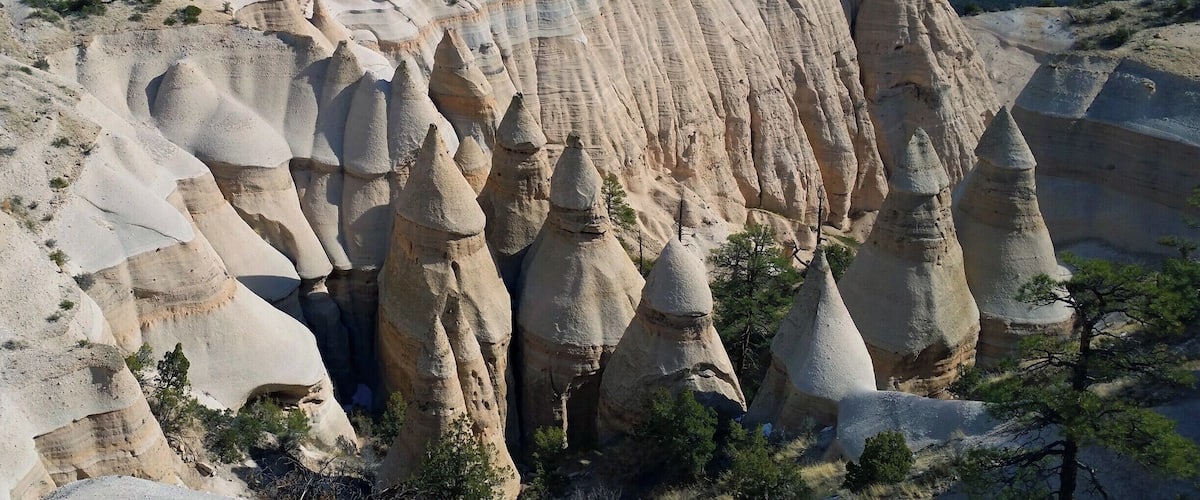 A landscape with prominent hoodoos and a distant mountain range.