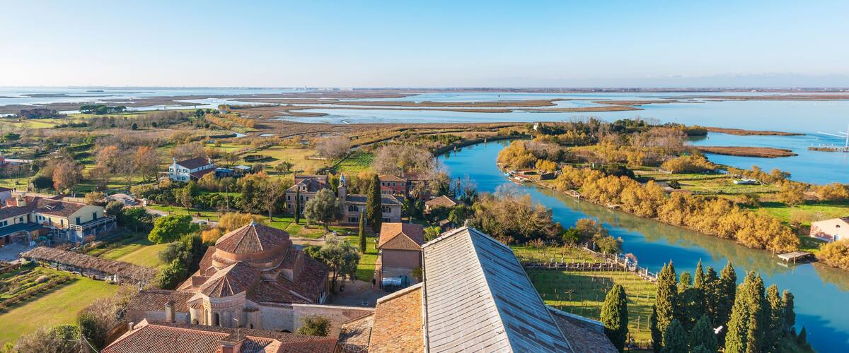 A river winding through a town with historic buildings and a large dome structure.