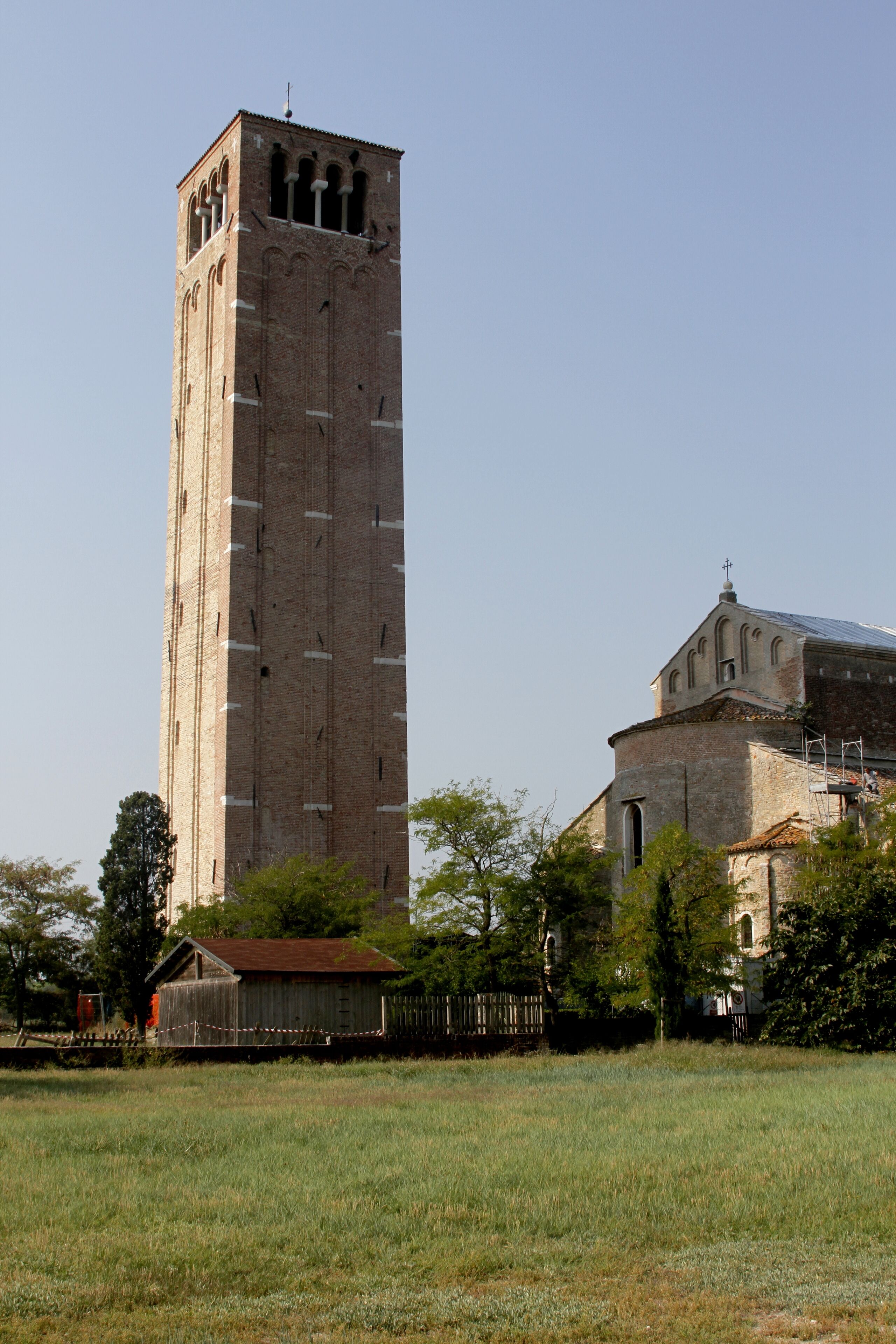 A tall brick tower and a historic church with a dome.