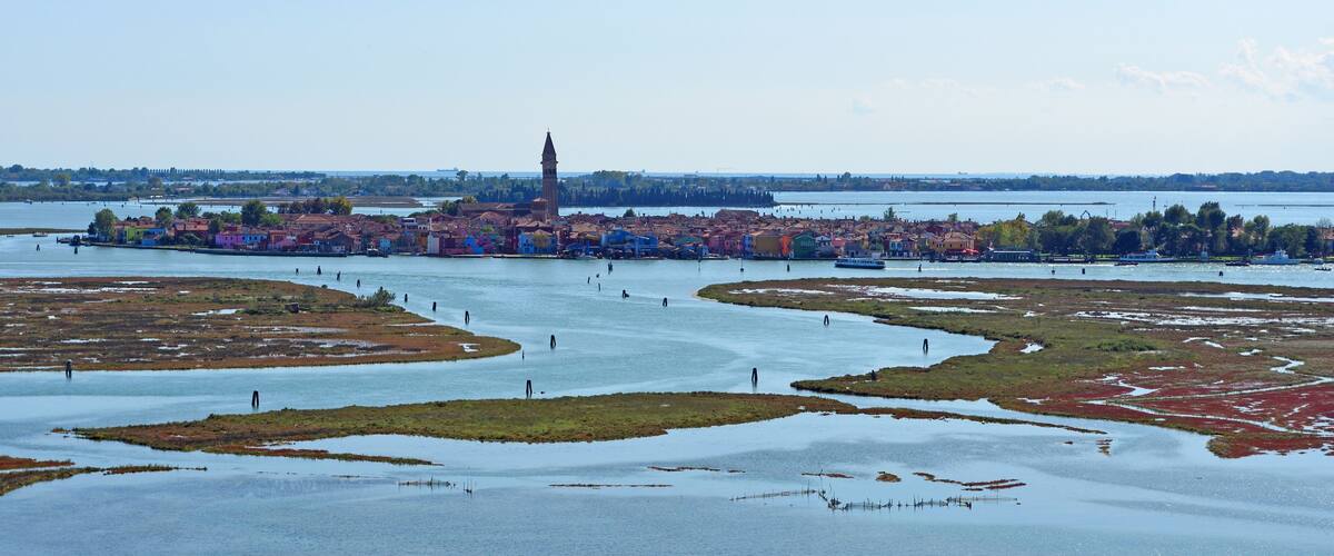 A riverside town with a prominent tower, colorful buildings, and a network of waterways.