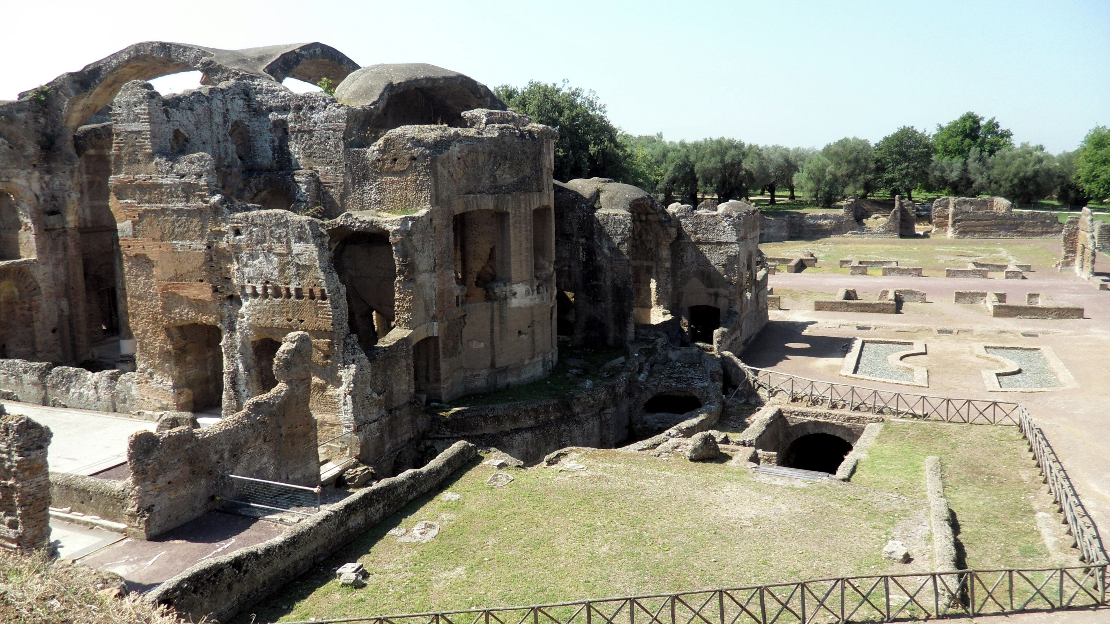 Ancient ruins with large stone structures and a well-maintained grassy area.