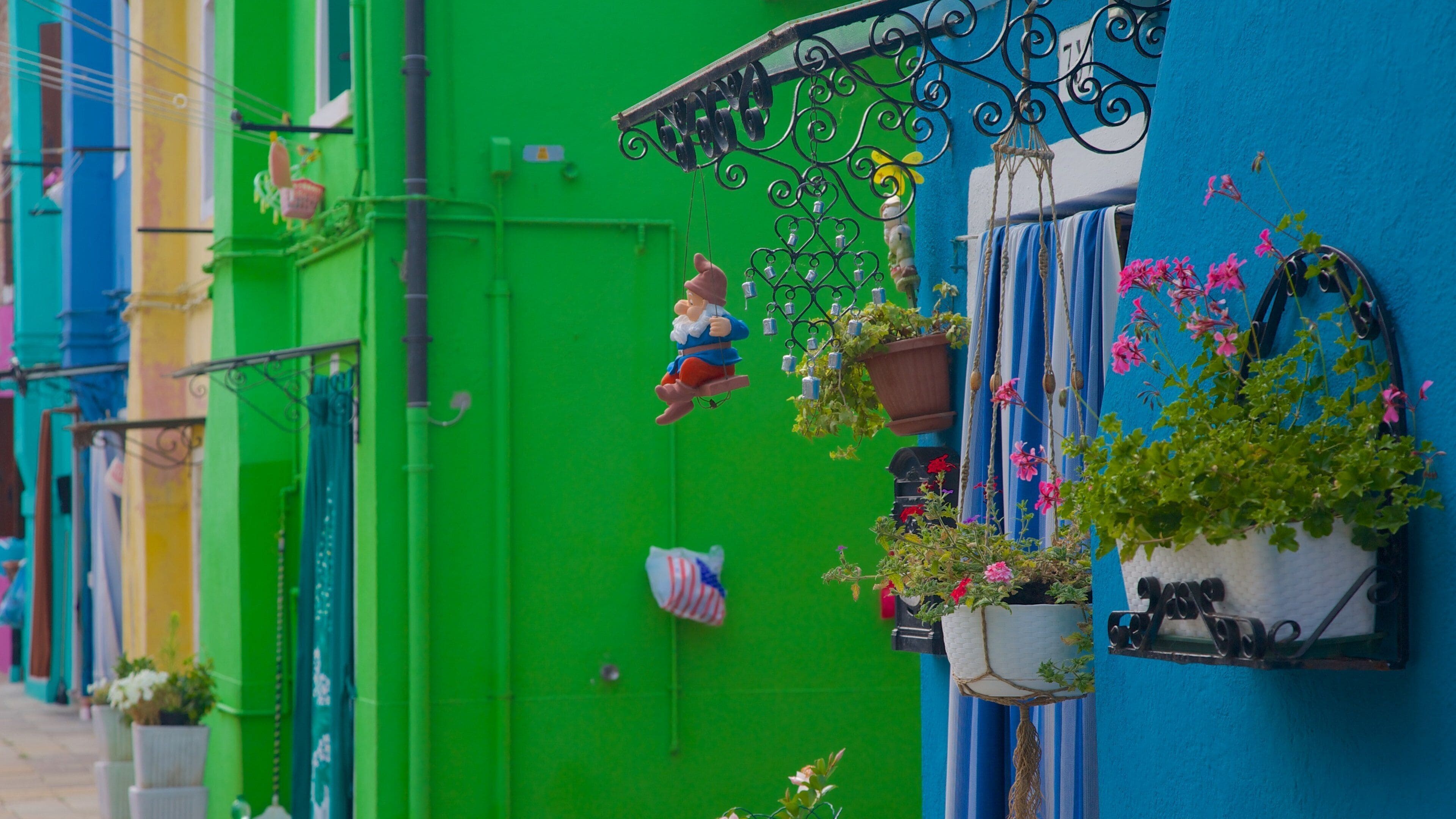 A colorful building with a green door, a blue wall, and a hanging ornament.