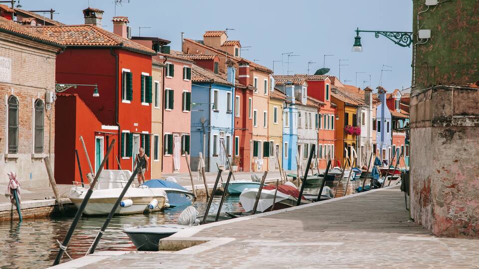 A narrow canal with colorful buildings on either side.