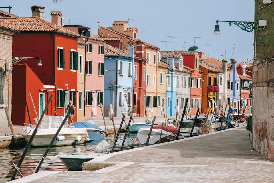 A narrow canal with colorful buildings on either side.
