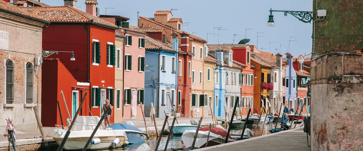 A narrow canal with colorful buildings on either side.