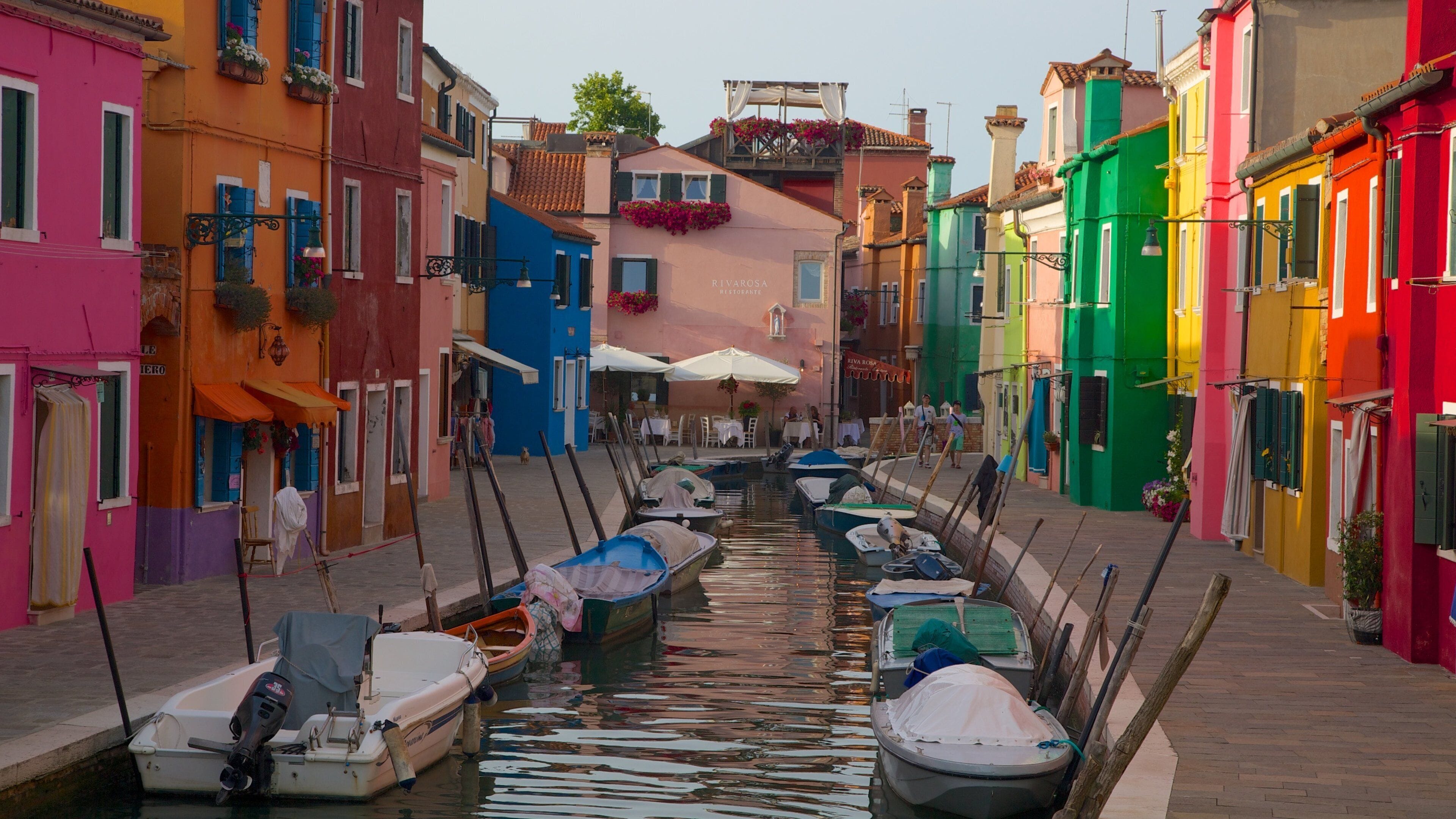 A narrow canal lined with colorful buildings and boats.