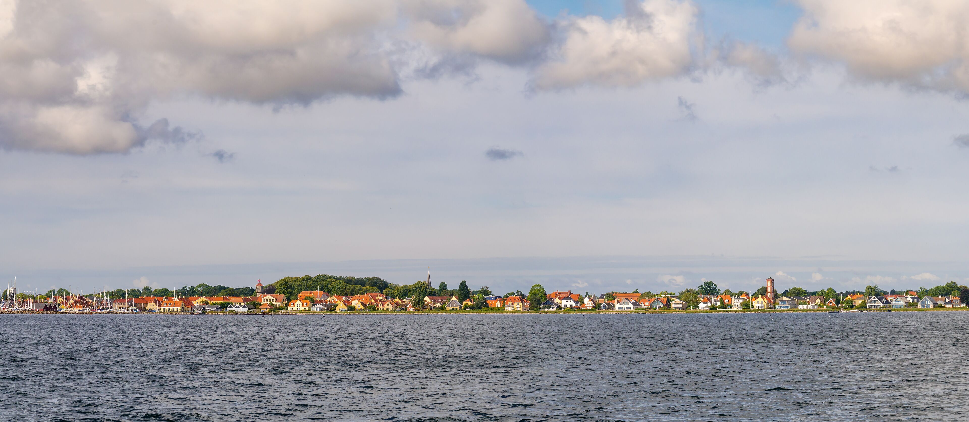 A coastal town with houses and a church by the water.