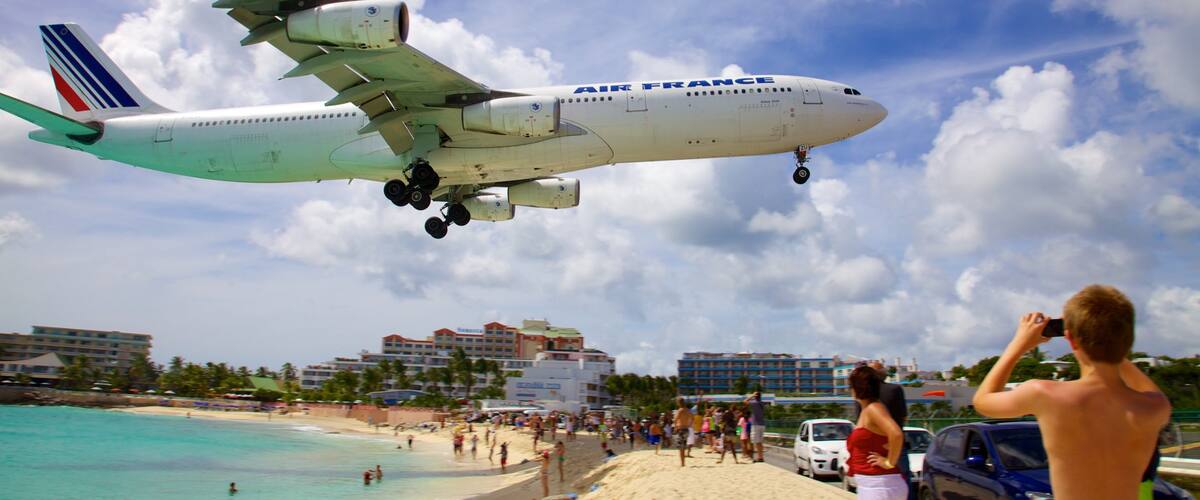 Maho Reef showing a sandy beach, a coastal town and tropical scenes