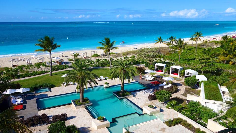 Grace Bay montrant plage de sable, hĂŽtel ou complexe de luxe et piscine