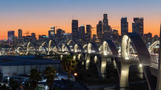 New 6th Street bridge in Los Angeles at sunset with the Los Angles skyline in the distance