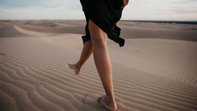 Crop view of woman walking barefoot on sand dune, Algodones Dunes, Brawley, USA