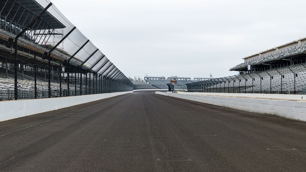 An empty racetrack with spectator stands on both sides.