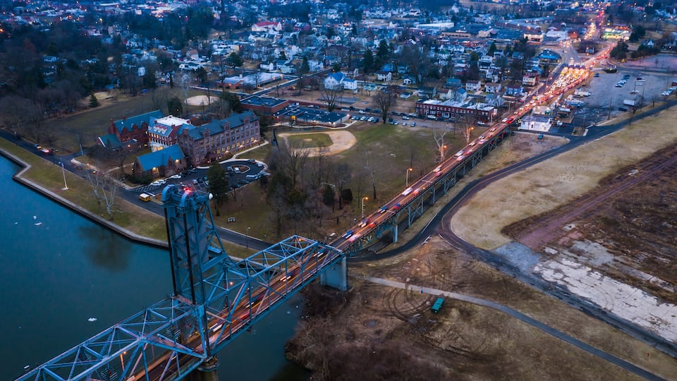 A bridge over a river with a town in the background.