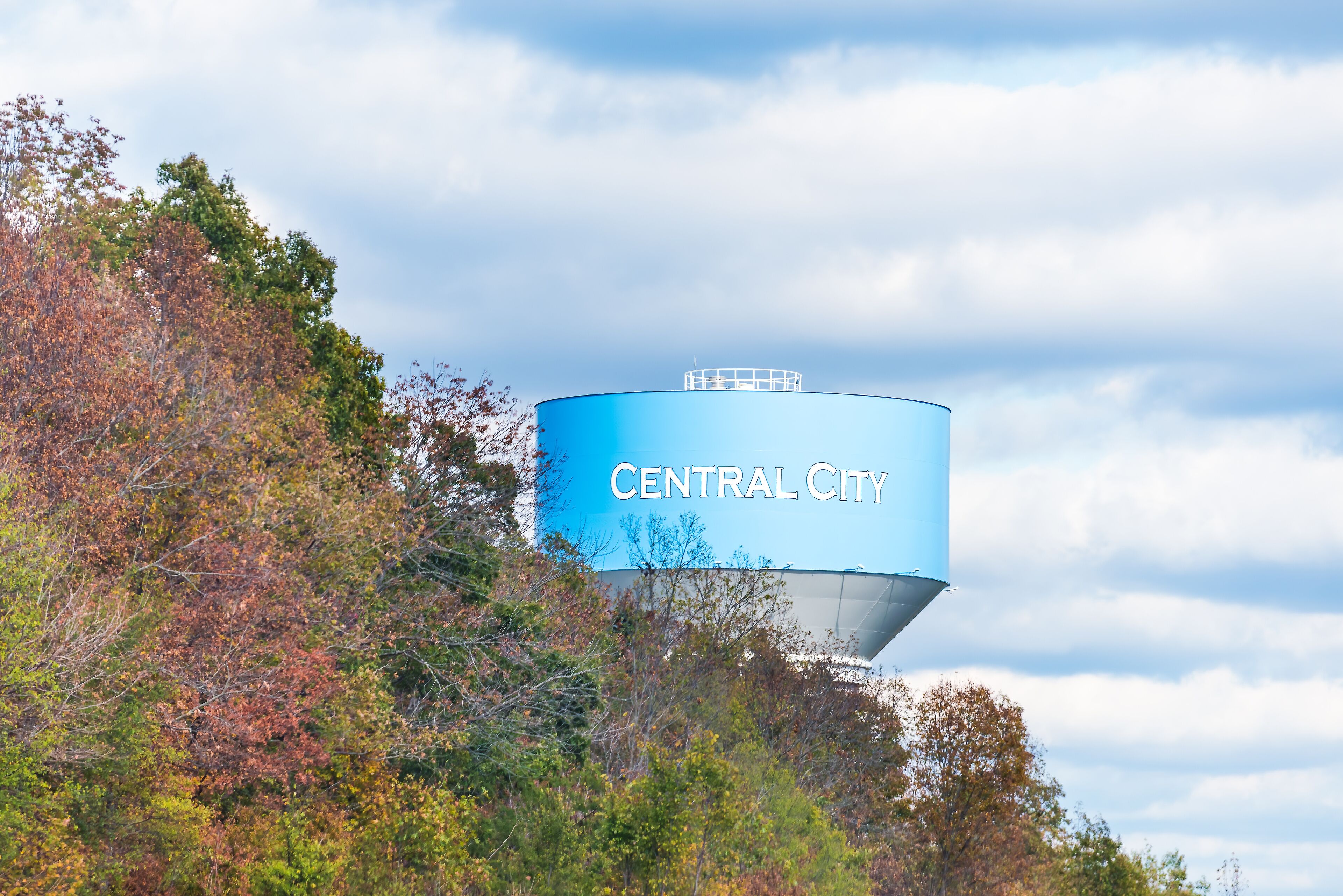 View of water tower sign for Central City in Kentucky countryside industrial town closeup and cloudy sky