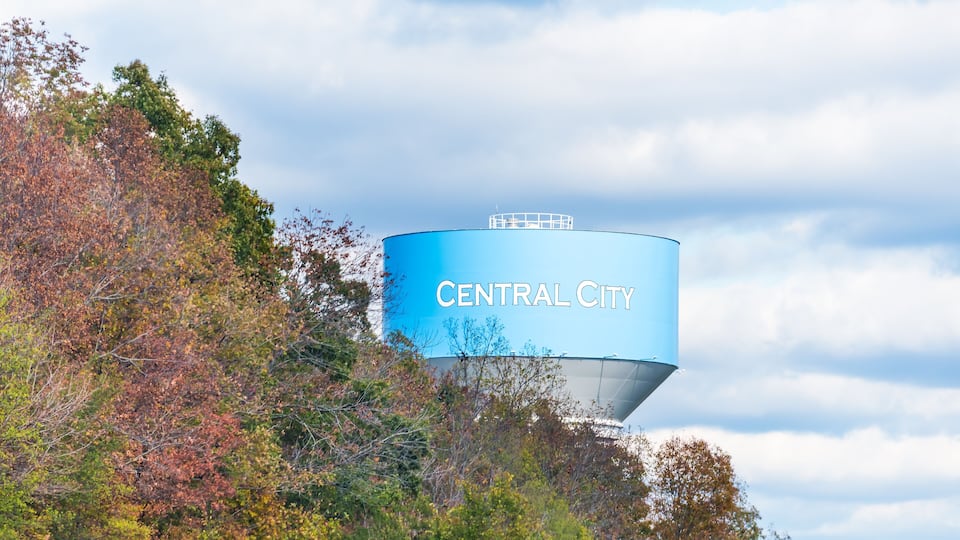 View of water tower sign for Central City in Kentucky countryside industrial town closeup and cloudy sky